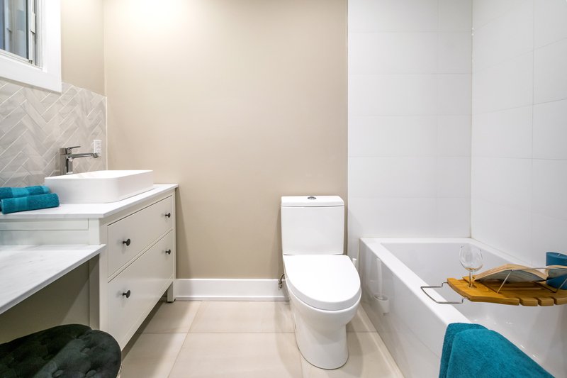 Cuarto de baño con inodoro y bañera blanco
