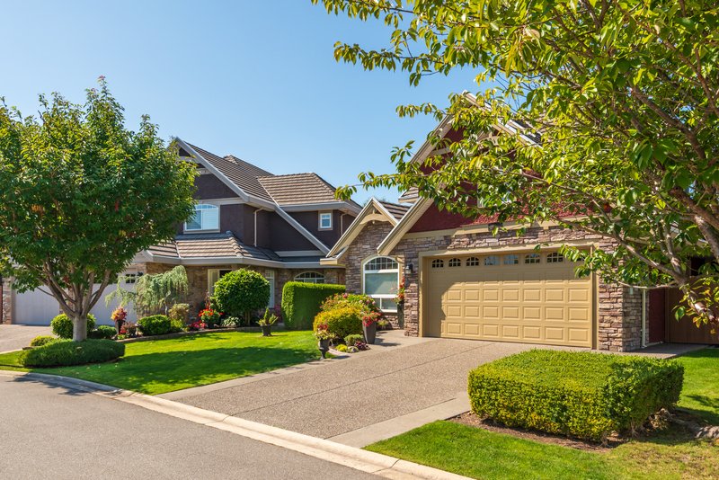 Frente de dos casas con jardín y cochera