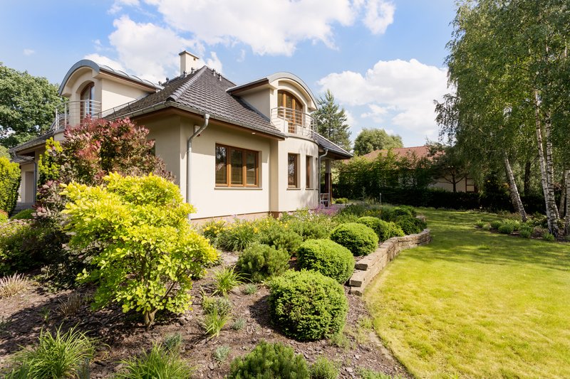 Toma de una casa moderna independiente con un gran jardín verde.