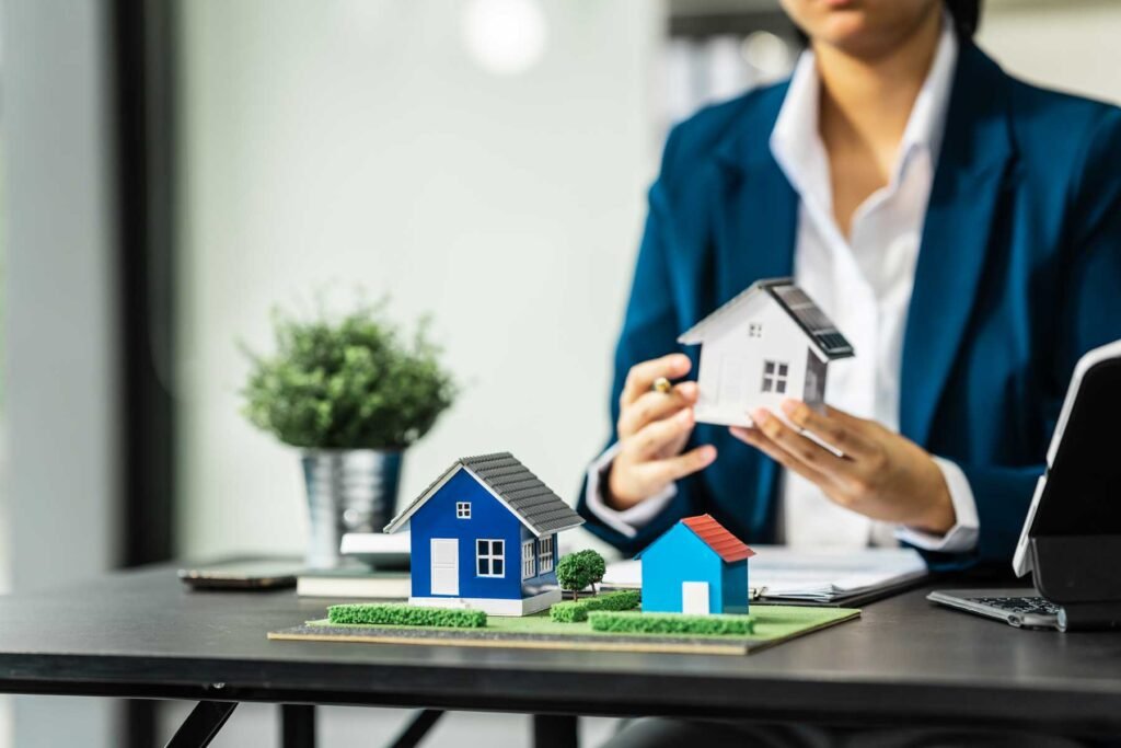 Agente de bienes riaces sosteniendo la maqueta de una cosa