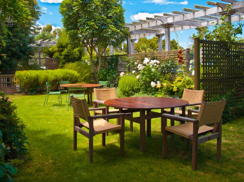 Mesa de comedor colocada en un jardín frondoso.